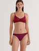 A model in the araks silk and cotton willow bralette and harriet panty in cranberry red