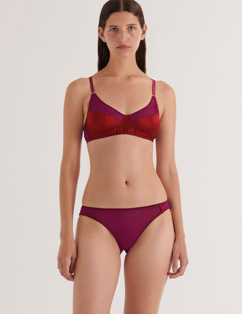 A model in the araks silk and cotton willow bralette and harriet panty in cranberry red
