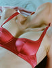 A model posing in a red silk Araks Gita bra. 