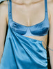 A model wearing Araks silk penelope bra in the color bluet, with a blue Araks slip layered on top. 
