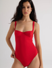 A model wearing the ume one piece in the shade scarlet red. 