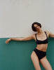 Model wearing Araks Ulija bikini top and Tonne bikini bottoms in black