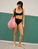 Model wearing Araks Ulija bikini top and Tonne bikini bottoms in black