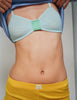 A close-up of a model wearing the Araks Uma bralette in Verona with Presley shorts in Pomelo