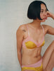 A model in the araks silk beatrice bralette and aaron panty in pomelo yellow