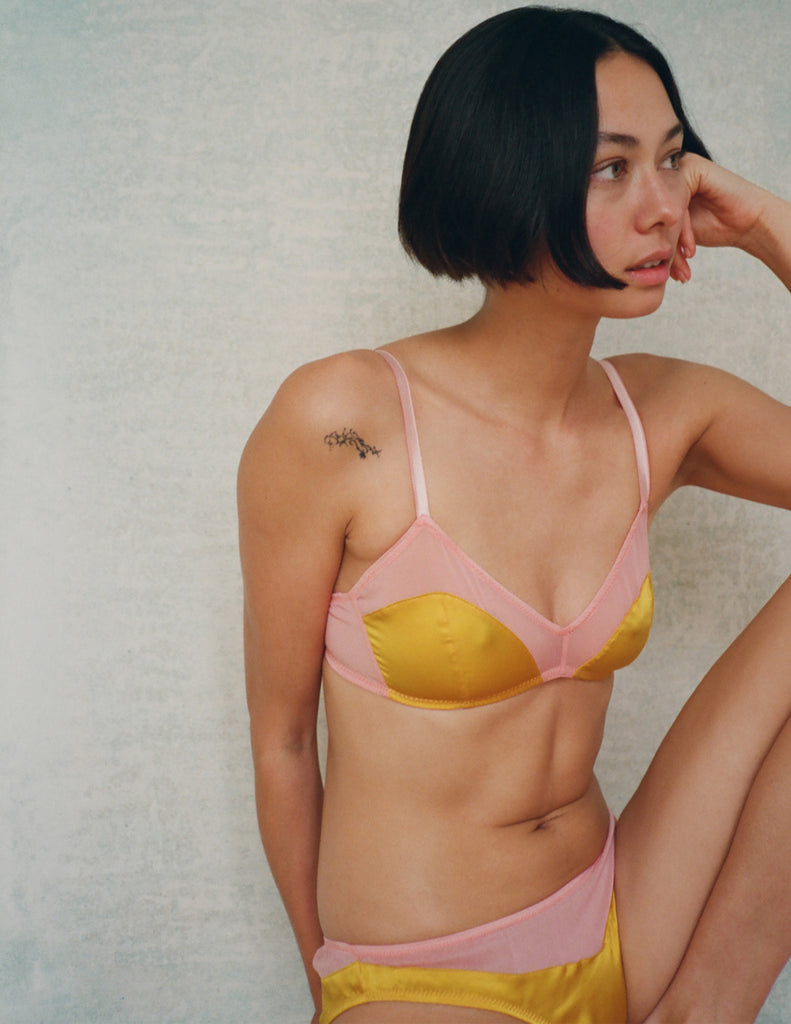 A model in the araks silk beatrice bralette and aaron panty in pomelo yellow