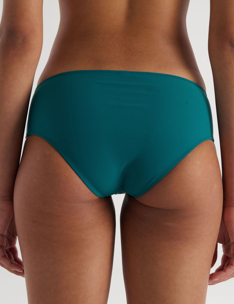 A model in the araks ezra bikini bottom in fern green