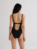A model wearing the ume one piece in the shade black. 