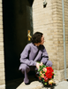A model posting outside a doorway while wearing the Araks Vivienne Crewneck in the shade Violette and the matching Vero sweatpants. 