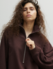 A model wearing the Araks matching dark brown lounge set, the Vivienne sweatshirt, and Vero sweatpants, both in the dark brown shade Mill. 