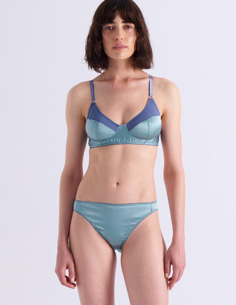 Model wearing Araks Willow bralette in Aegean blue in front of a off white background