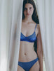 A model wearing a silk and cotton crepe bra and panty set, the willow bralette and harriet panty in storm blue