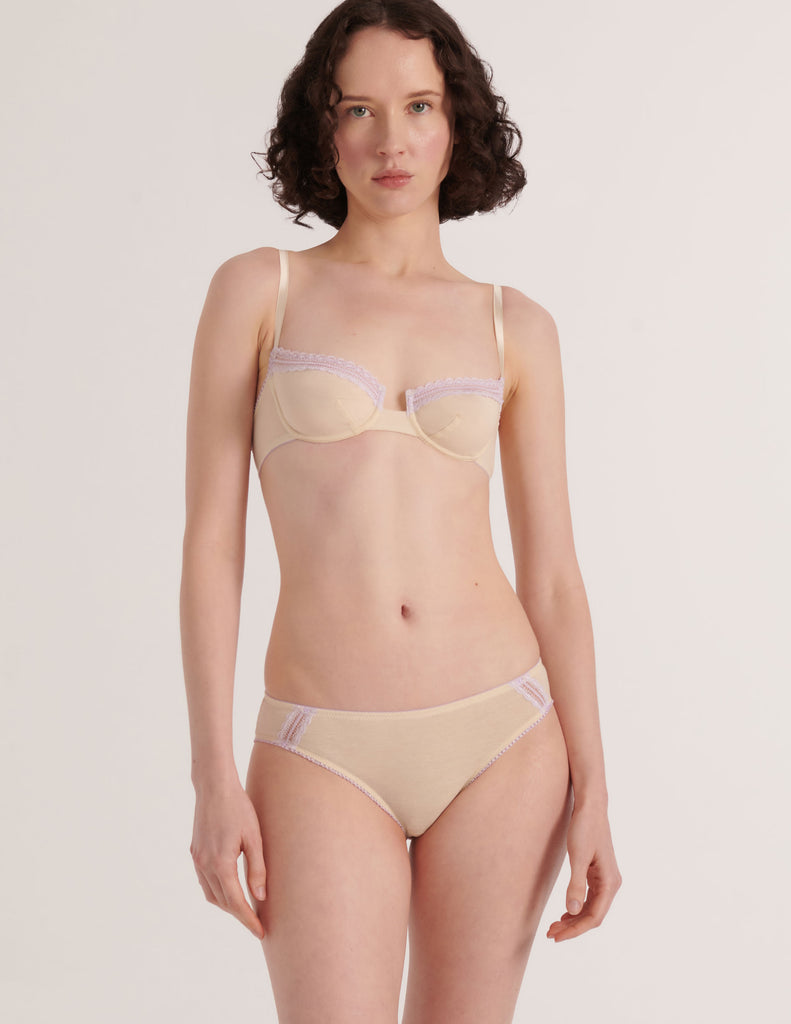 Woman wearing a Araks Cream cotton Chloe bra with lavendar lace trim