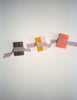Three colorful square Araks handmade soap on a white surface