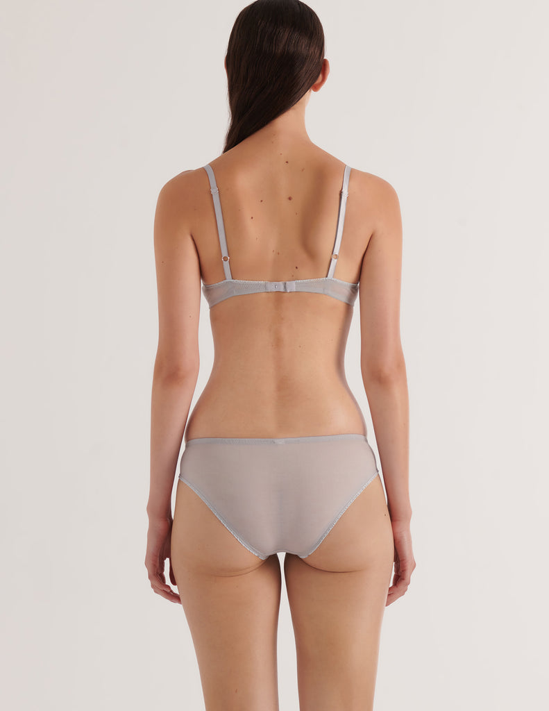 a back view of a model in the araks cotton crepe chloe underwire bra and sonja panty in mist blue grey
