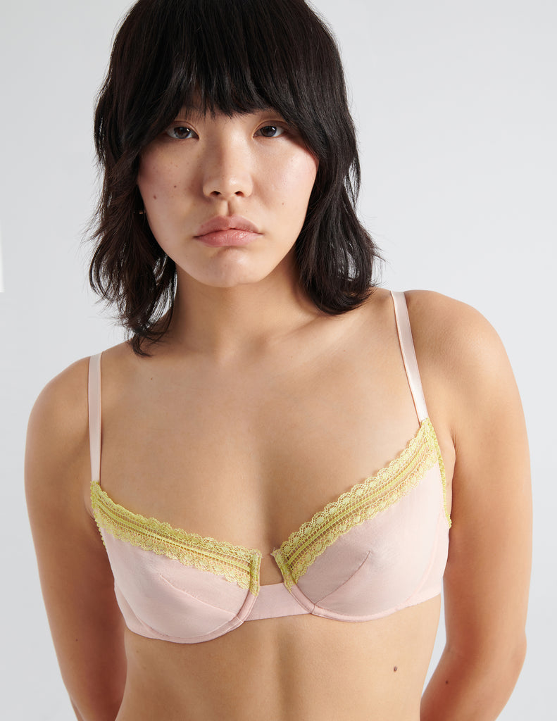 Detail front shot image of model wearing peach colored  cotton crepe underwire bra with matching panties. 