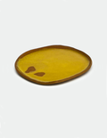 A handmade ceramic plate by Lisa Kaye in yellow with brown trim