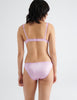Back view of model wearing pink silk underwire bra with matching silk panties. 