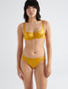 Front view image of model wearing golden silk underwire bra with matching panties. 