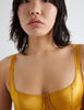 Detail shot of model wearing golden silk underwire bra. 