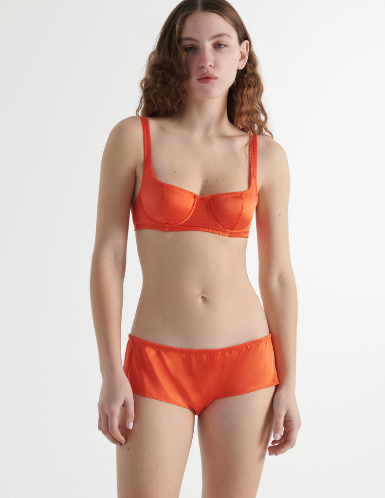 Woman in orange silk Gita Underwire bra and hipster