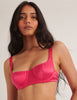 a model wearing the araks gita silk underwire bra in rouge red