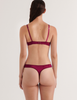 A model in the araks silk gita underwire bra and grier thong in cranberry red
