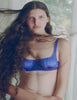 Woman wearing an Araks silk underwire blue bra with long hair blowing in the wind.