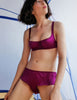 Woman wearing a purple underwire bra with matching silk short inside a tent
