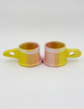 Two peter shire handmade sculptural mugs in yellow and pink