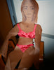 Woman sitting down in a pink bra and panty