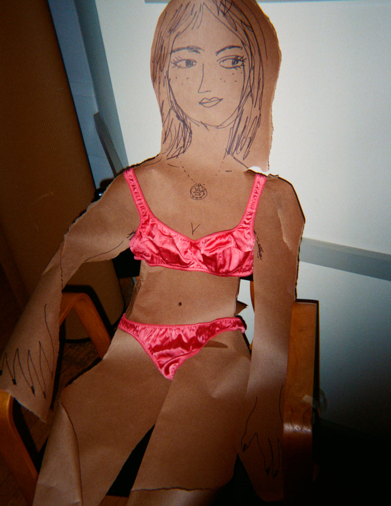 Woman sitting down in a pink bra and panty