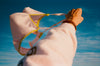 A person holding a pink bra in the sky.