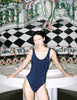 Woman wearing Araks Harley One Piece swimsuit in navy with red polka dots