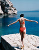 A model in the araks quinn bikini top and tolle bikini bottom in papaya orange