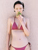 A model in the araks nelle bikini top and nadia bikini bottom in cerise