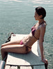 A model in the araks nelle bikini top and nadia bikini bottom in cerise