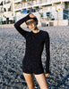 Model wearing Araks Undine rashguard with Polly swim shorts in navy with red polka dots