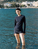 Model wearing Araks Undine rashguard with Polly swim shorts in navy with red polka dots