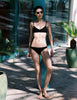 A model in the araks tessa bikini top and piper bikini bottom in black