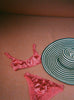 A pink bra and panty set with a stripe hat.