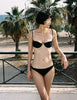 a model in the ovsanna bikini top and piper bikini bottom in black