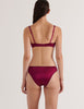 A model in the araks silk penelope bralette and gwyneth panty in cranberry red
