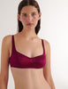 A model in the araks silk penelope bralette in cranberry red