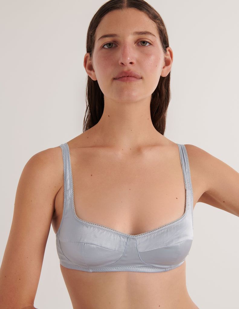 A model in the araks silk penelope bralette in glace blue