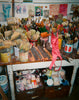 Art supplies including brushes, paint cans, and a pink bra on a cluttered desk. 