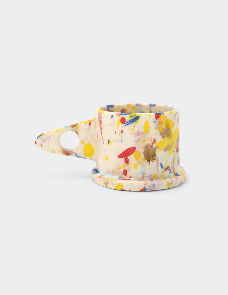 Colorful splatter-patterned Peter Shire mug on a white background