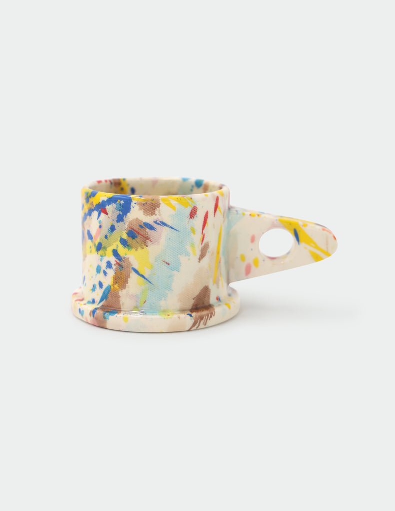 Colorful splatter-patterned Peter Shire mug on a white background
