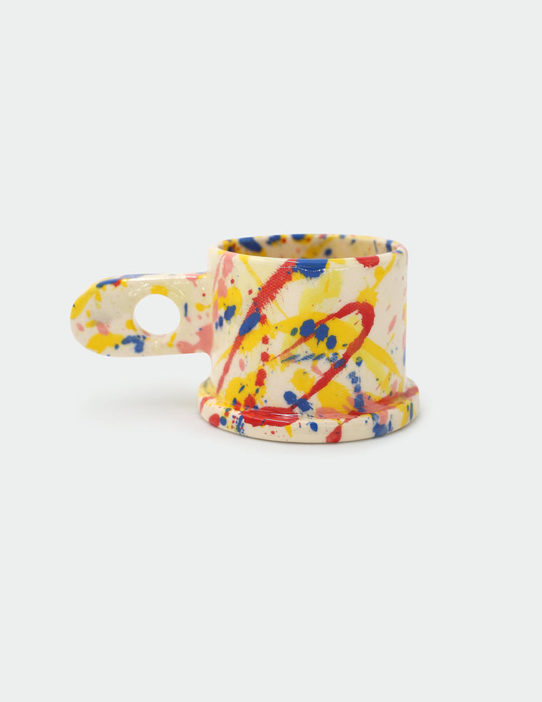 Colorful splatter-patterned Peter Shire mug on a white background