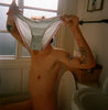 A person holding panties in the bathroom.